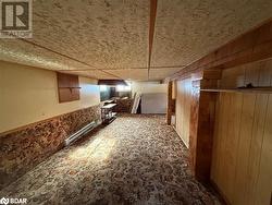 Basement with wooden walls and a baseboard heating unit - 