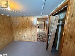 Additional living space with carpet and wood walls - 