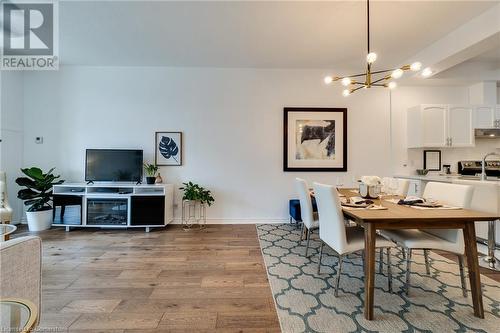 Dining space with light hardwood / wood-style floors and an inviting chandelier - 262 Dundas Street E Unit# 317, Hamilton, ON - Indoor