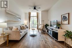 Living room with ceiling fan and wood-type flooring - 