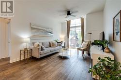 Living room with hardwood / wood-style flooring and ceiling fan - 