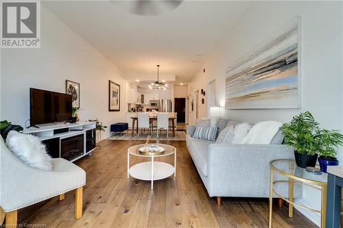 Living room with a notable chandelier and wood-type flooring - 262 Dundas Street E Unit# 317, Hamilton, ON - Indoor Photo Showing Living Room