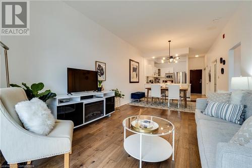 Living room featuring wood-type flooring and a chandelier - 262 Dundas Street E Unit# 317, Hamilton, ON - Indoor Photo Showing Living Room