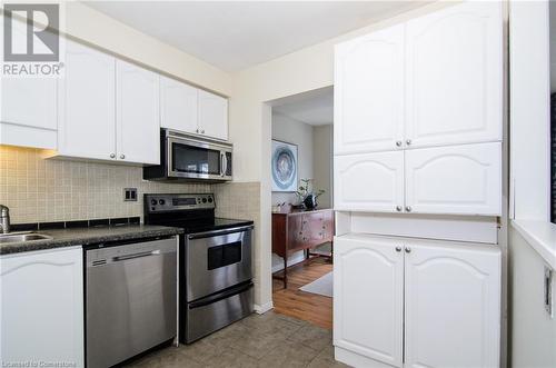 Kitchen with light wood-type flooring, stainless steel appliances, white cabinetry, and sink - 79 Braeheid Avenue Avenue Unit# 6, Hamilton, ON - Indoor Photo Showing Kitchen With Stainless Steel Kitchen