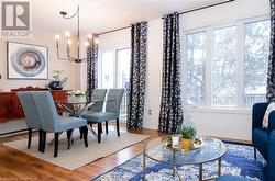 Dining room with hardwood / wood-style floors, a wealth of natural light, and an inviting chandelier - 