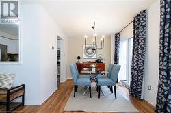 Dining area with hardwood / wood-style floors and a notable chandelier - 