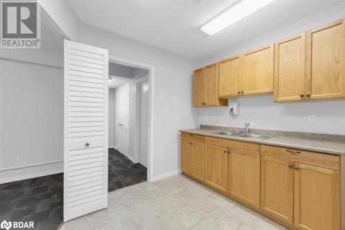 Kitchen with sink, light tile patterned floors, and light brown cabinets - 108 Russell Street N, Madoc, ON 