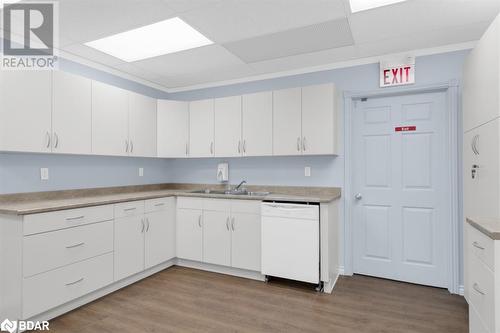 Kitchen featuring dishwasher, wood-type flooring, white cabinets, and sink - 108 Russell Street N, Madoc, ON 