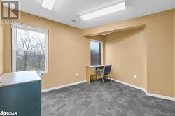 Unfurnished office featuring dark colored carpet and a textured ceiling - 