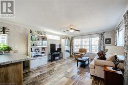 Living room with a textured ceiling, ceiling fan, and crown molding - 