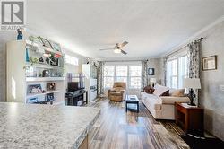 Living room with a textured ceiling, dark hardwood / wood-style floors, and crown molding - 