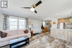 Living room featuring ceiling fan and crown molding - 