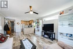 Living room featuring light hardwood / wood-style flooring, ceiling fan, and ornamental molding - 