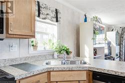 Kitchen featuring dishwasher, light brown cabinets, crown molding, and sink - 