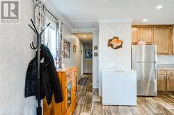 Kitchen featuring refrigerator, light hardwood / wood-style flooring, stainless steel refrigerator, and ornamental molding - 