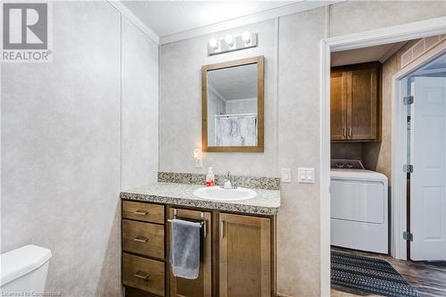 Bathroom with washer / clothes dryer, toilet, vanity, and ornamental molding - 99 Fourth Conc Road, Burford, ON - Indoor Photo Showing Laundry Room