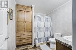 Bathroom featuring crown molding, a textured ceiling, toilet, vanity, and hardwood / wood-style flooring - 