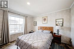 Bedroom featuring wood-type flooring and ornamental molding - 