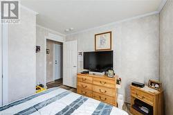 Bedroom with dark hardwood and crown molding - 