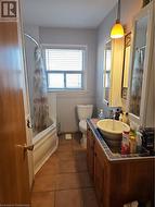 Full bathroom with toilet, tile patterned floors, vanity, and shower / tub combo with curtain - 