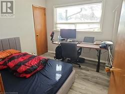 Bedroom featuring light hardwood / wood-style floors and multiple windows - 