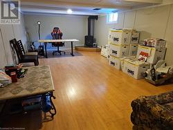 Recreation room with hardwood / wood-style flooring and a wood stove - 