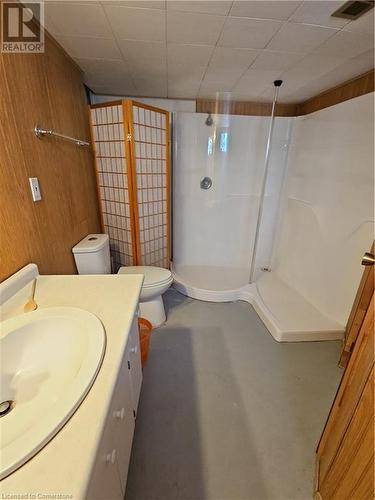 Bathroom with a shower, wood walls, concrete flooring, toilet, and vanity - 140 Alvin Street, Waterloo, ON - Indoor Photo Showing Bathroom