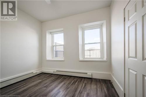 Third bedroom with luxury vinyl plank flooring, 8 ft closet with sliding doors and two large windows looking out to private deck. - 28 Main Street Unit# 1, Cambridge, ON - Indoor Photo Showing Other Room