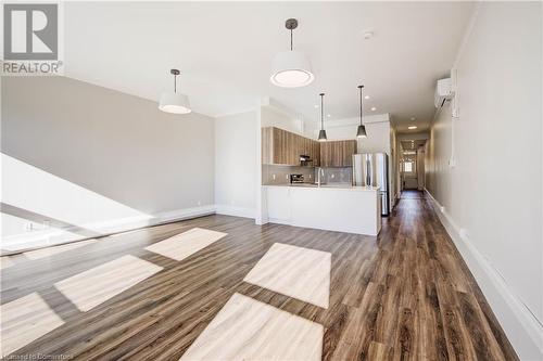 Kitchen with pendant lighting, breakfast bar and stainless steel appliances - 28 Main Street Unit# 1, Cambridge, ON - Indoor Photo Showing Kitchen