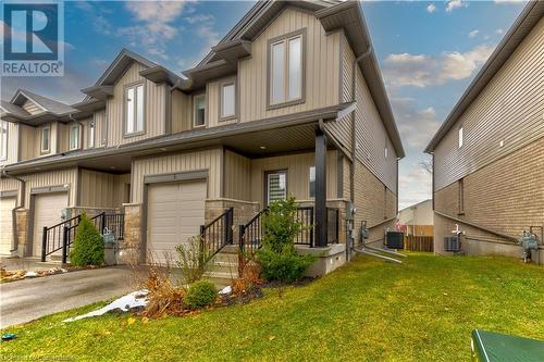 View of front of home with cooling unit, a front yard, and a garage - 1023 Devonshire Avenue Unit# 5, Woodstock, ON - Outdoor