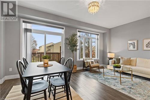 Dining area featuring a wealth of natural light, dark hardwood / wood-style floors, and a notable chandelier - 1023 Devonshire Avenue Unit# 5, Woodstock, ON - Indoor