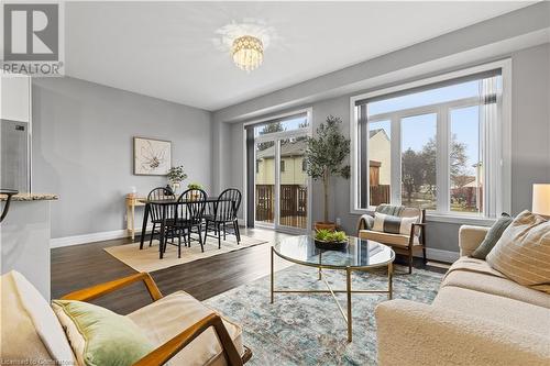 Living room with dark hardwood / wood-style floors and an inviting chandelier - 1023 Devonshire Avenue Unit# 5, Woodstock, ON - Indoor Photo Showing Living Room