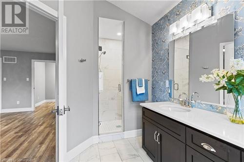 Bathroom featuring hardwood / wood-style floors, vanity, and a shower with door - 1023 Devonshire Avenue Unit# 5, Woodstock, ON - Indoor Photo Showing Bathroom