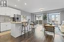 Kitchen featuring decorative backsplash, dark hardwood / wood-style flooring, a kitchen island, stainless steel fridge with ice dispenser, and white cabinetry - 1023 Devonshire Avenue Unit# 5, Woodstock, ON  - Indoor 