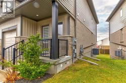 View of property exterior featuring central AC unit, a garage, and a yard - 