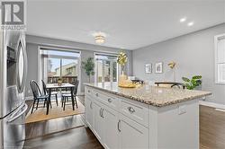 Kitchen featuring light stone counters, dark hardwood / wood-style flooring, white cabinetry, and stainless steel refrigerator with ice dispenser - 