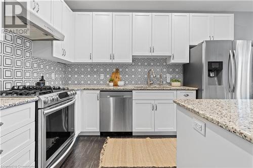 Kitchen with decorative backsplash, stainless steel appliances, white cabinetry, and sink - 1023 Devonshire Avenue Unit# 5, Woodstock, ON - Indoor Photo Showing Kitchen With Stainless Steel Kitchen With Upgraded Kitchen