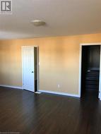 Empty room with a textured ceiling and dark hardwood / wood-style flooring - 