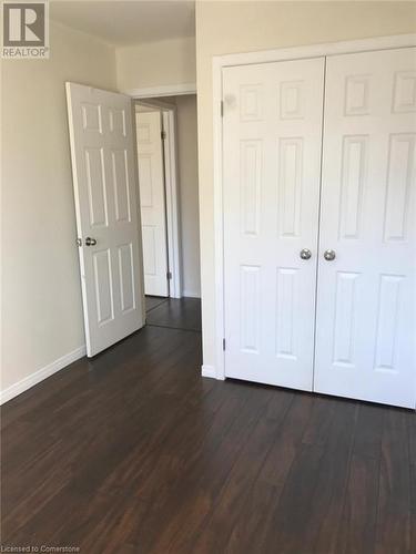 Unfurnished bedroom featuring a closet and dark hardwood / wood-style flooring - 11 Sorrento Street, Kitchener, ON - Indoor Photo Showing Other Room