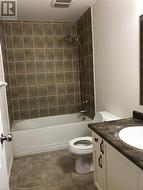 Full bathroom featuring tiled shower / bath combo, toilet, and vanity - 