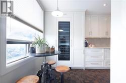 Eating area with view of full size wine fridge and pantry. - 