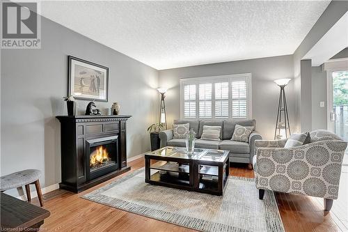 Hardwood floors with California Shutters and electric fireplace - 15 Gregg Court Unit# 1, Kitchener, ON - Indoor Photo Showing Living Room With Fireplace