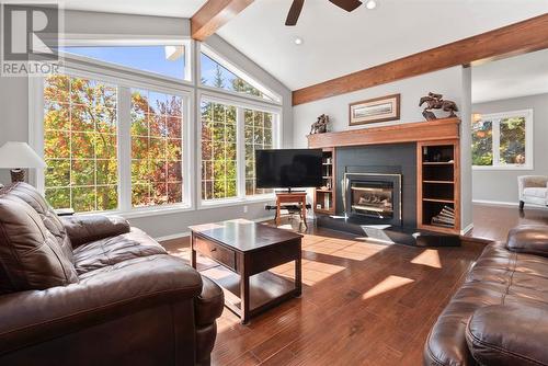 Living room has lots of natural light thanks to the large SW facing windows and is centered around a gas fireplace - 209, 27475 Township Road 380, Rural Red Deer County, AB 