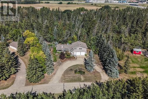 Aerial view of the front. Trees line both the sides and the back of property providing for privacy and nature views from all angles - 209, 27475 Township Road 380, Rural Red Deer County, AB 