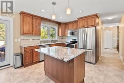 Kitchen has darker stained oak cabinetry, granite countertops and a stainless steel appliance package - 