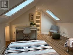 Bedroom with light hardwood / wood-style flooring and lofted ceiling - 