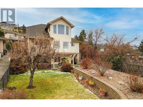 Backyard with mature landscaping and stone retaining wall - 620 Arrowleaf Lane, Kelowna, BC - Outdoor