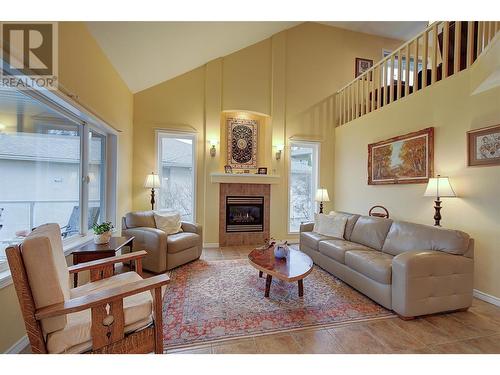 Soaring vaulted ceiling - 620 Arrowleaf Lane, Kelowna, BC - Indoor Photo Showing Living Room With Fireplace