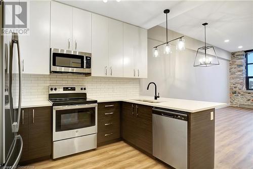 Kitchen with white upper cabinets and dark lower cabinets, appliances with stainless steel finishes - 15 Main Street Unit# 404, Cambridge, ON - Indoor Photo Showing Kitchen With Stainless Steel Kitchen With Double Sink With Upgraded Kitchen