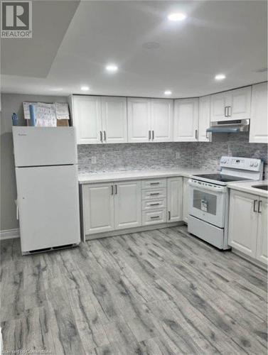 Kitchen featuring backsplash, white cabinetry, white appliances, and light wood-type flooring - 155 Norfolk Avenue, Cambridge, ON - Indoor Photo Showing Kitchen